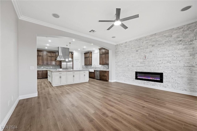 unfurnished living room with crown molding, a fireplace, ceiling fan, and wood-type flooring