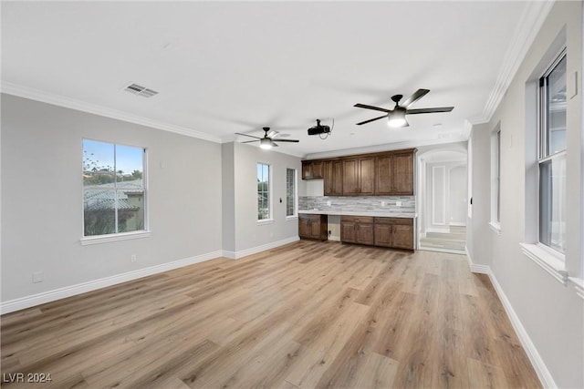 unfurnished living room featuring ceiling fan, a healthy amount of sunlight, light hardwood / wood-style floors, and crown molding