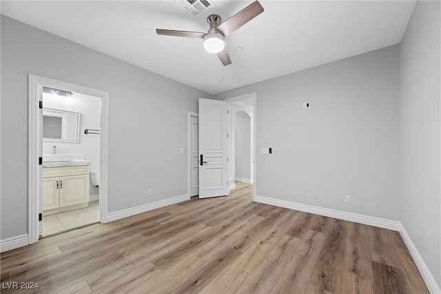 unfurnished bedroom with ensuite bathroom, light hardwood / wood-style flooring, and ceiling fan