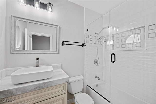 full bathroom with vanity, toilet, and bath / shower combo with glass door