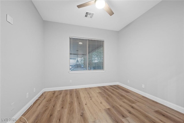 unfurnished room featuring a ceiling fan, visible vents, baseboards, and wood finished floors