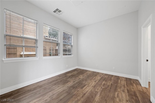 unfurnished room with visible vents, baseboards, and wood finished floors