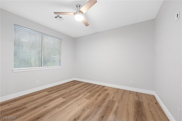 empty room with ceiling fan and light hardwood / wood-style flooring