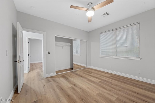 unfurnished bedroom featuring a closet, light hardwood / wood-style flooring, and ceiling fan