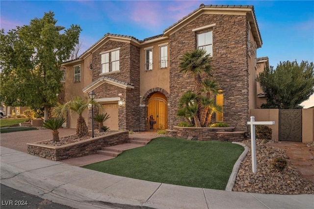 view of front of property featuring a yard and a garage