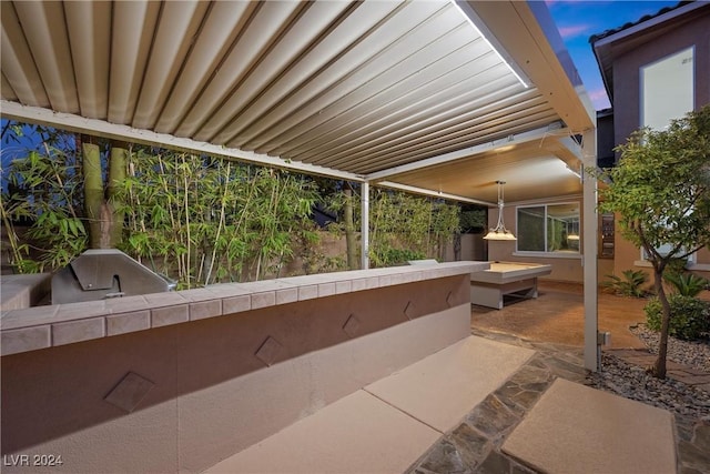 patio terrace at dusk with exterior kitchen