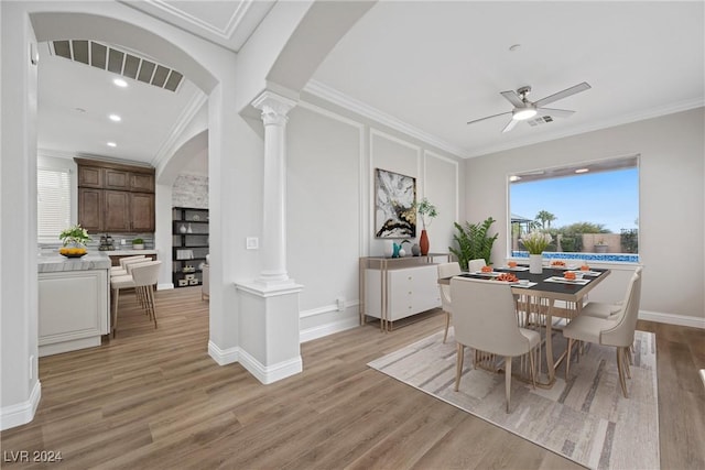 dining space featuring arched walkways, ornamental molding, and ornate columns