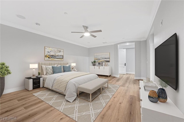 bedroom featuring ornamental molding, baseboards, light wood finished floors, and a ceiling fan