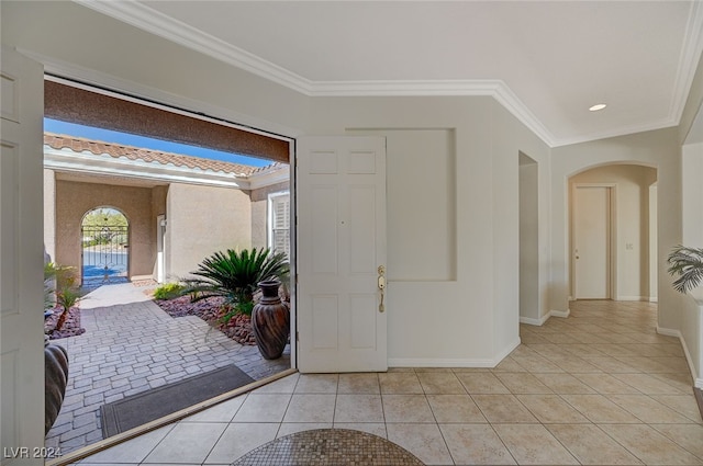 foyer featuring crown molding and light tile patterned floors