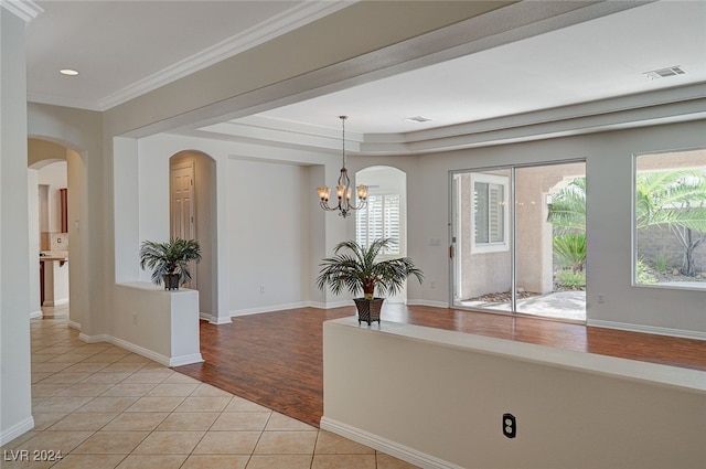 interior space with ornamental molding, a chandelier, and light tile patterned flooring