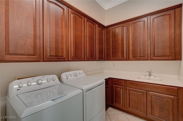 laundry room featuring independent washer and dryer, ornamental molding, sink, light tile patterned floors, and cabinets