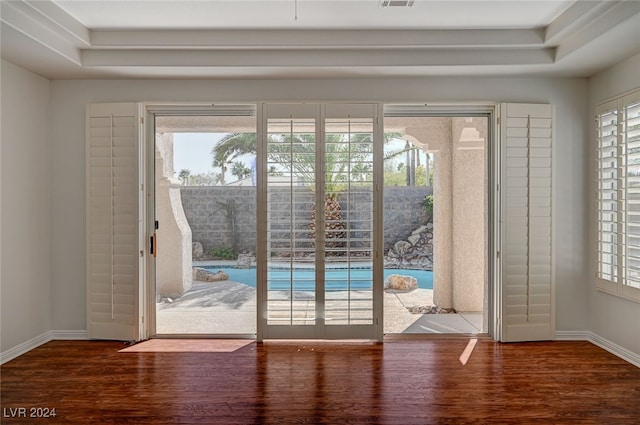 doorway to outside featuring a healthy amount of sunlight and dark hardwood / wood-style flooring