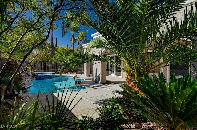 view of swimming pool with an in ground hot tub and a patio