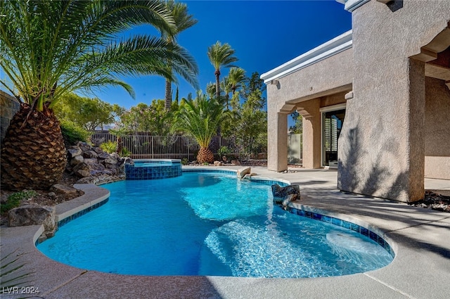 view of swimming pool featuring a patio area and an in ground hot tub