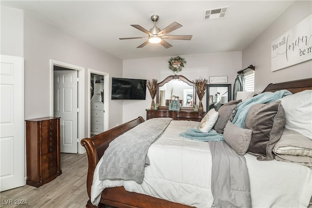 bedroom featuring visible vents, light wood finished floors, and ceiling fan