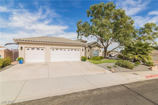 view of front of house featuring an attached garage, stucco siding, concrete driveway, and a tile roof
