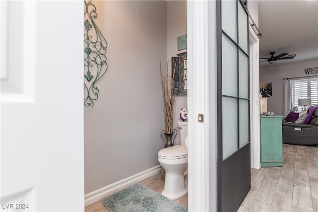 bathroom with ceiling fan, toilet, and hardwood / wood-style floors