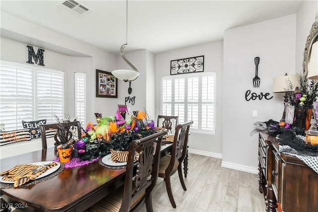 dining room featuring baseboards, light wood finished floors, and visible vents