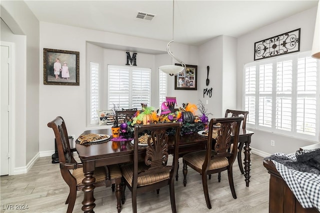 dining room featuring light wood-style floors, baseboards, and visible vents