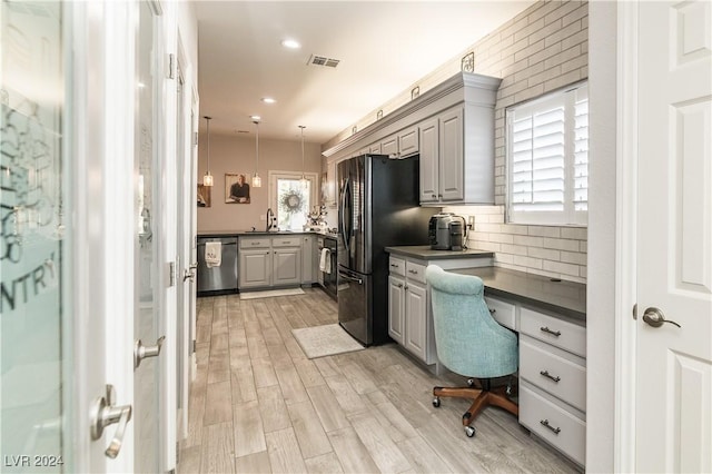 home office featuring visible vents, built in study area, recessed lighting, a sink, and light wood finished floors