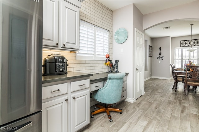 office area with built in desk and light hardwood / wood-style flooring