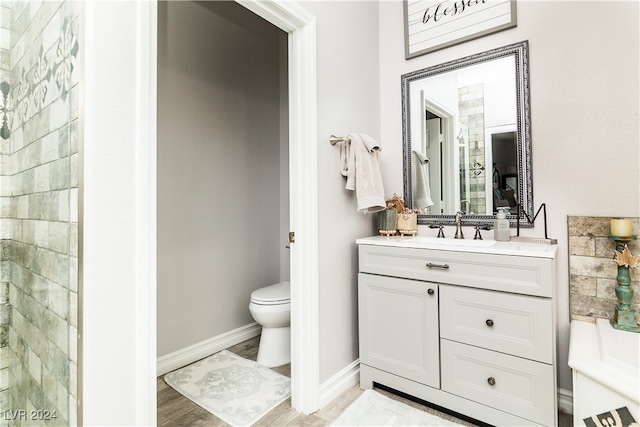 bathroom featuring vanity, toilet, a shower, and hardwood / wood-style floors