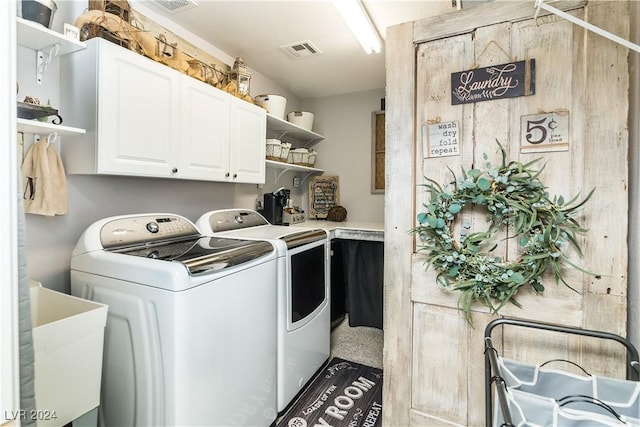 washroom with a sink, washing machine and dryer, cabinet space, and visible vents