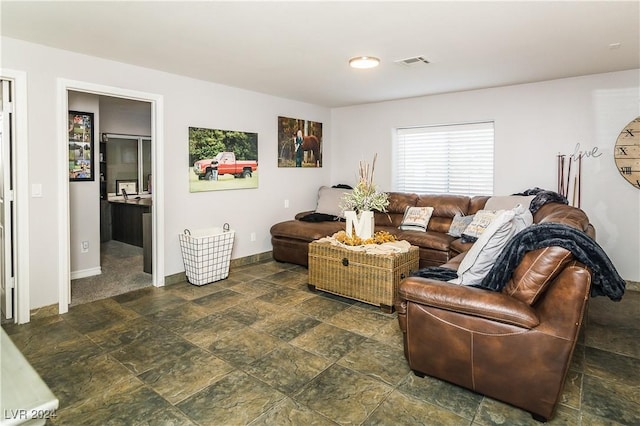 living area featuring visible vents, baseboards, and stone finish floor