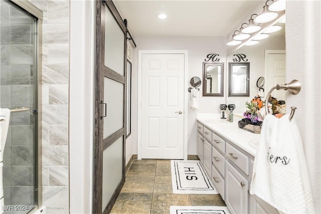 full bathroom featuring double vanity, stone finish floor, a stall shower, a sink, and recessed lighting