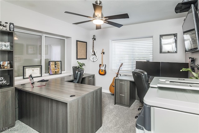 carpeted office space featuring ceiling fan