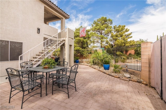 view of patio / terrace with a fenced backyard, outdoor dining area, and stairway