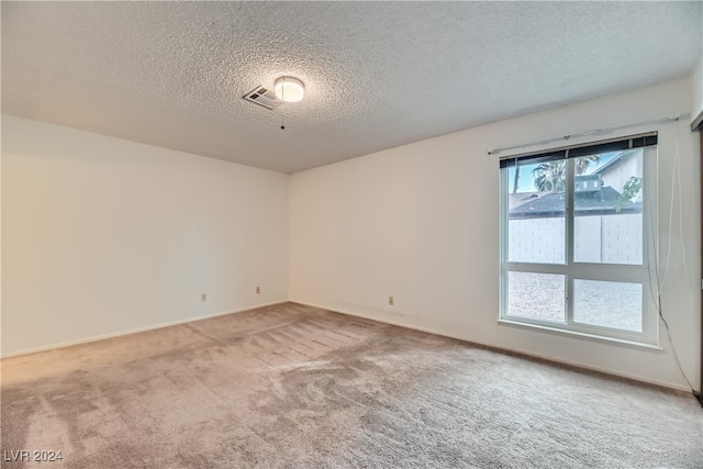 carpeted spare room with a textured ceiling