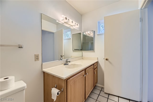 bathroom with toilet, vanity, and tile patterned floors