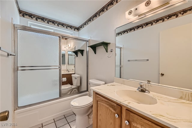 full bathroom featuring tile patterned flooring, shower / bath combination with glass door, vanity, and toilet