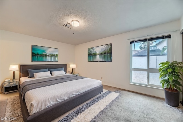 carpeted bedroom featuring a textured ceiling