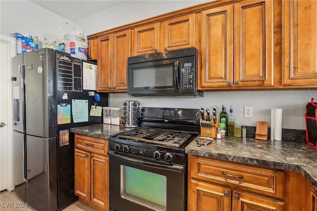 kitchen with black appliances and dark stone countertops