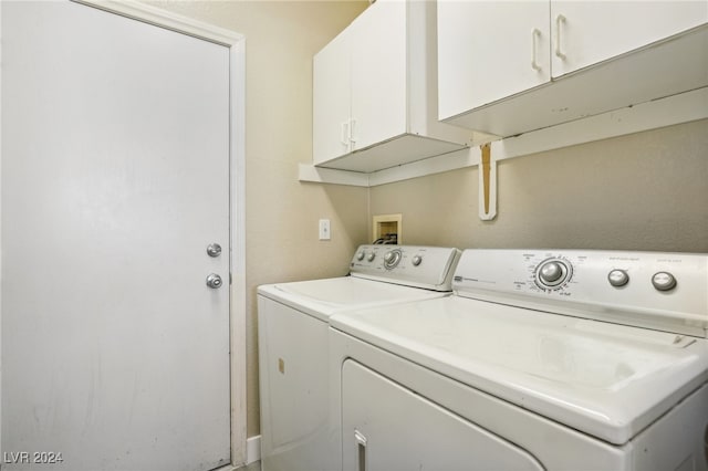 laundry area featuring washing machine and clothes dryer and cabinets