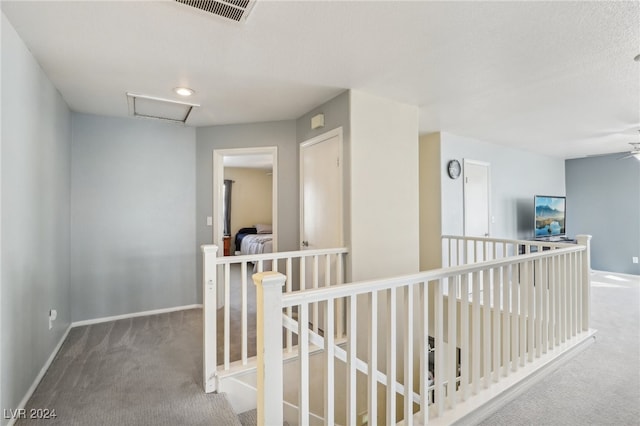 hallway featuring a textured ceiling and carpet