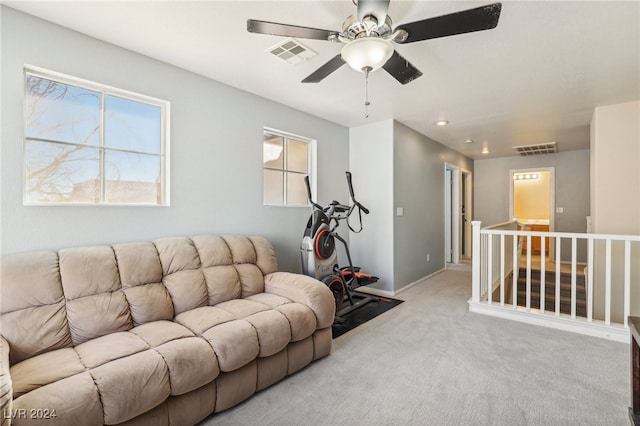 carpeted living room with ceiling fan