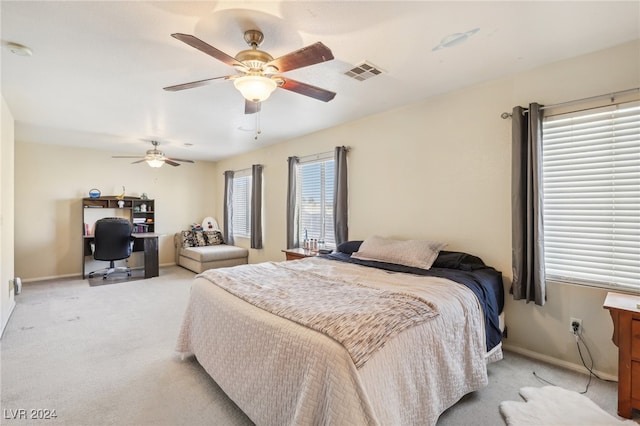 bedroom featuring multiple windows, light colored carpet, and ceiling fan