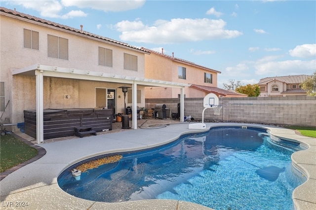 view of pool with area for grilling, a patio area, and a hot tub