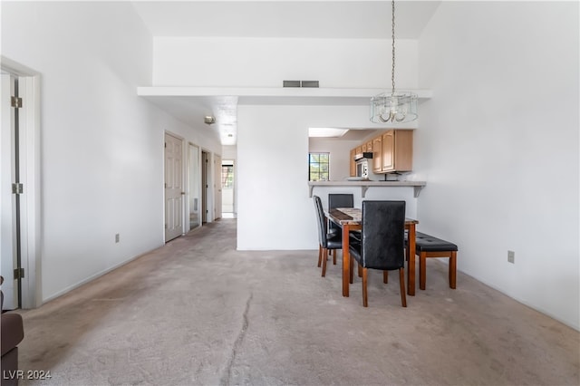 carpeted dining space with an inviting chandelier