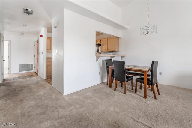 carpeted dining space with a notable chandelier