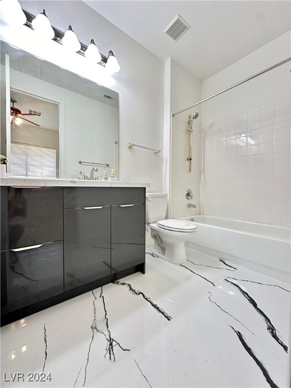 full bathroom featuring vanity, toilet, tiled shower / bath combo, and ceiling fan