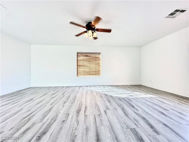 spare room with ceiling fan and light wood-type flooring