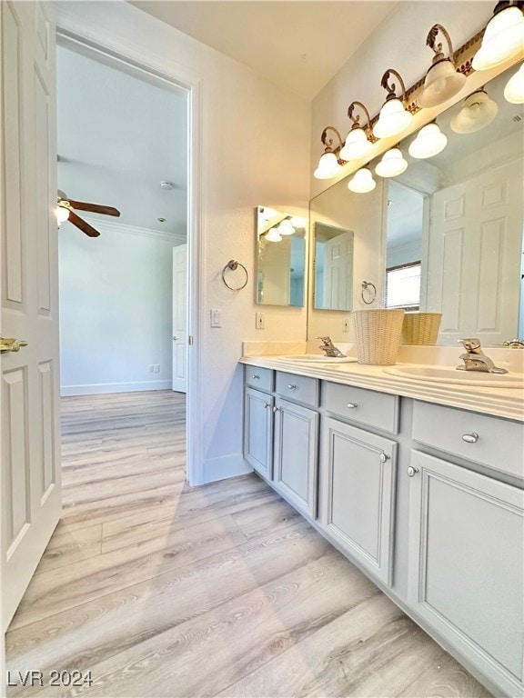 bathroom featuring vanity, crown molding, hardwood / wood-style flooring, and ceiling fan