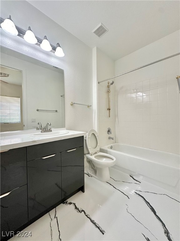 full bathroom with vanity, tiled shower / bath combo, and toilet