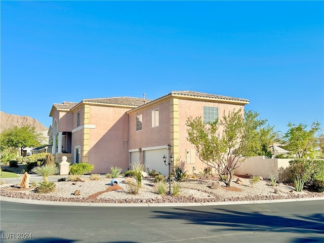 view of side of property with a garage and a mountain view