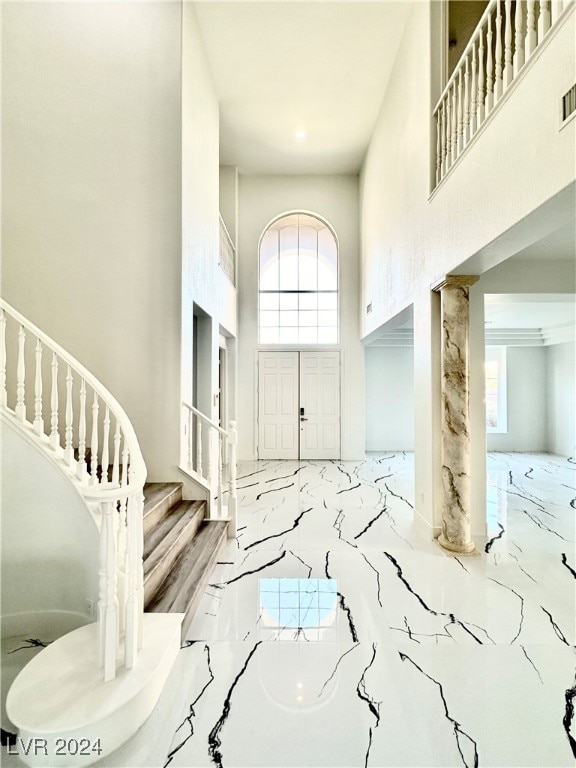 foyer entrance featuring a towering ceiling