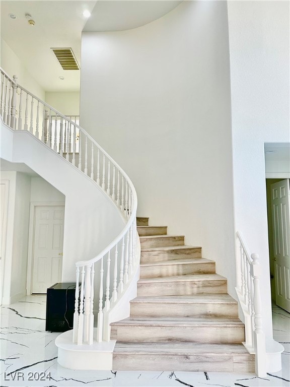 staircase featuring a towering ceiling